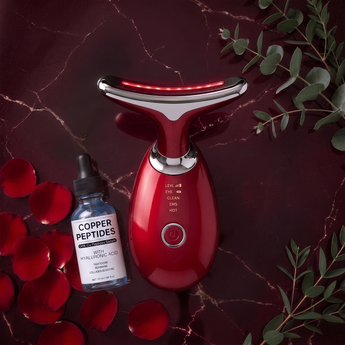 LumiSculpt Glow System bundle — Ruby Red LED sculptor with LumiGlow copper peptide serum on burgundy marble with rose petals